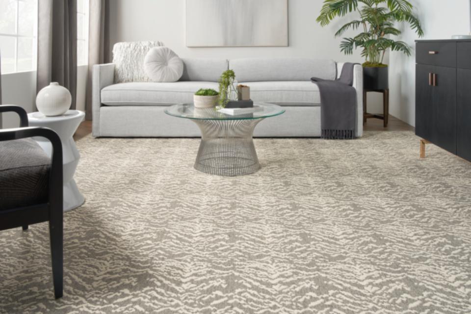 grey beige patterned carpet in living room with grey couch and black accent furniture.